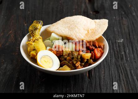 Lontong Cap Go Meh. Indonesische Peranakan-Suppe oder Lontong Sayur mit Opor Ayam Chicken Curry, würzigem Chayote Curry, SAmbel Goreng ATI K Stockfoto