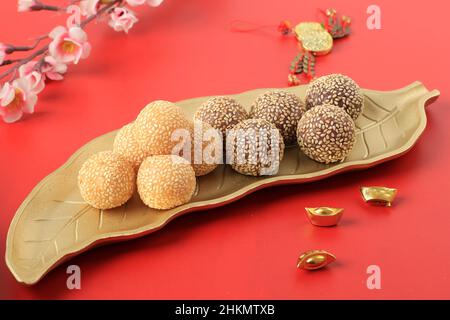 Onde-Onde- oder klejeous Ris Sesam Ball, serviert auf indonesischem Bali-Teller im traditionellen Stil. Nahaufnahme. Beliebter indonesischer Snack mit chinesischem Influ Stockfoto