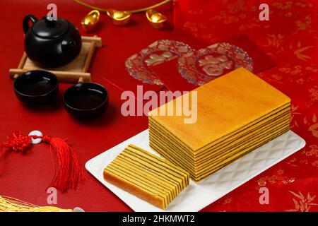 Chinesischer Charakter ist Fu, bedeutet Glück. Lapis Legit, traditionelle indonesische tausendschichtige Torte mit chinesischem Neujahrsrot-Konzept. Stockfoto