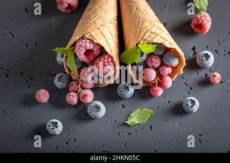 Süßes Eis als Symbol für fruchtiges Eis. Eis im Kegel aus gefrorenen Früchten. Stockfoto