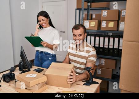 Männer und Frauen, die im Geschäft mit dem Smartphone sprechen und das Etikett mit einem Barcode-Lesegerät scannen Stockfoto