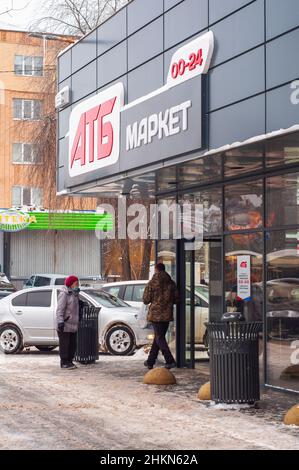 Kropyvnyzkyj, Ukraine. Dezember 29. 2021. Eintritt in den atb-Markt des neuen Designs, eine alte Frau in einer Maske, im Winter. Das schwierige Leben im Ruhestand Stockfoto