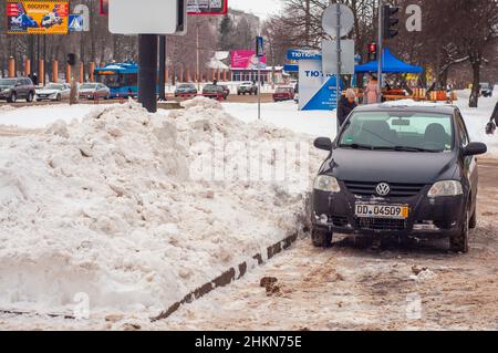 Kropyvnyzkyj, Ukraine. Dezember 29. 2021. Auto im Winter im Schnee, schlechtes Wetter. Schneefall in der Stadt, Verkehreinsturz. Schneewehe so hoch wie ein Auto. Stockfoto