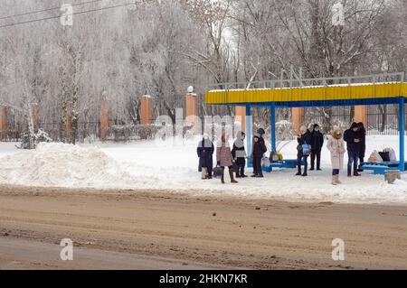 Kropyvnyzkyj, Ukraine. Dezember 29. 2021. Öffentliche Verkehrsmittel halten im Winter im Schnee mit Menschen. Schneefall in der Stadt, Verkehreinsturz. Stockfoto