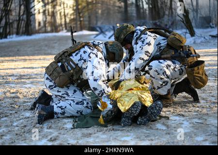 Pripjat, Ukraine. 04th. Februar 2022. Zwei ukrainische Soldaten der Nationalgarde wenden während einer städtischen Kampfübung, die das ukrainische Innenministerium im Dorf Pripjat in der Nähe der weißrussischen Grenze abgehalten hat, eine Notfalldecke auf einen simulierten Verletzten an, während die russischen Streitkräfte am 4. Februar an den Grenzen des Landes weiter mobilisieren. 2022 in Pripyat, Ukraine. (Foto von Justin Yau/Sipa USA) Quelle: SIPA USA/Alamy Live News Quelle: SIPA USA/Alamy Live News Stockfoto