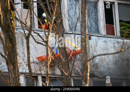 Pripjat, Ukraine. 04th. Februar 2022. Feuerwehrleute evakuieren einen Raum im zweiten Stock mit einem Abfallkorb während einer städtischen Kampfübung, die im Dorf Pripjat nahe der weißrussischen Grenze vom ukrainischen Innenministerium abgehalten wurde, während die russischen Streitkräfte am 4. Februar 2022 in Pripjat, Ukraine, weiter an den Grenzen des Landes mobilisieren. (Foto von Justin Yau/Sipa USA) Quelle: SIPA USA/Alamy Live News Quelle: SIPA USA/Alamy Live News Stockfoto