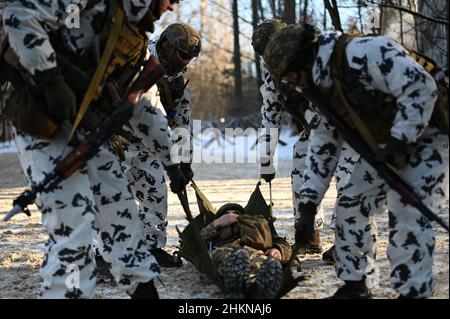 Pripjat, Ukraine. 04th. Februar 2022. Soldaten der ukrainischen Nationalgarde tragen während einer städtischen Kampfübung, die das ukrainische Innenministerium im Dorf Pripyat nahe der weißrussischen Grenze durchgeführt hat, einen simulierten Unfall auf einer Kampfbahre, während die russischen Streitkräfte am 4. Februar 2022 in Pripyat weiter an den Grenzen des Landes mobilisieren. Ukraine. (Foto von Justin Yau/Sipa USA) Quelle: SIPA USA/Alamy Live News Quelle: SIPA USA/Alamy Live News Stockfoto