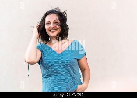 Mittlere Alter zuversichtlich, Brünette Frau stehend und lächelnd Stockfoto
