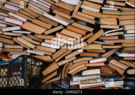 Auf dem Petrivka-Buchmarkt am Stadtrand von Kiew, Ukraine, werden Stapel von Büchern - Texte, Romane, Belletristik und Sachbücher - gestapelt. Stockfoto