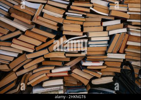 Auf dem Petrivka-Buchmarkt am Stadtrand von Kiew, Ukraine, werden Stapel von Büchern - Texte, Romane, Belletristik und Sachbücher - gestapelt. Stockfoto