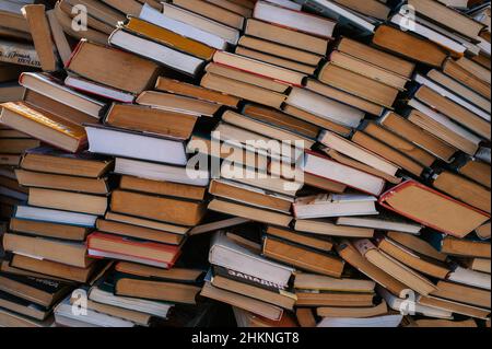 Auf dem Petrivka-Buchmarkt am Stadtrand von Kiew, Ukraine, werden Stapel von Büchern - Texte, Romane, Belletristik und Sachbücher - gestapelt. Stockfoto