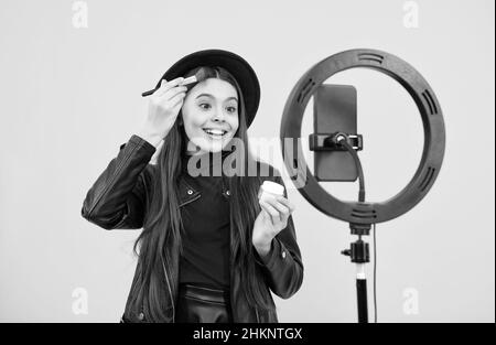 Happy teen Mädchen blogger verwenden Selfie LED Lampe und Smartphone auf Stativ, Blog. Stockfoto