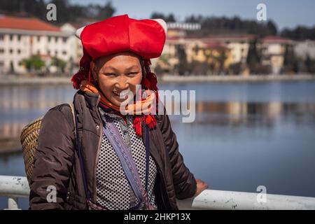 In Sapa, Provinz Lao Cai, Vietnam, trägt eine Frau aus einer ethnischen Minderheit der Roten Dao eine typische Kopfbedeckung und lächelt. Stockfoto