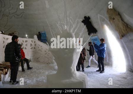 Kaschmir, Indien. 05th. Februar 2022. 5. Februar 2022, Srinagar, Jammu und Kashmir, Indien: Indische Touristen fotografieren in Asiens größtem Iglu Cafe aus Schnee in Gulmarg. Das Igloo Cafe ist etwa 37,5 Meter hoch und 45 Meter rund und bietet Platz für 15 Tische und etwa 60 Gäste. Das Igloo Cafe bietet Tische aus Eis und Schnee, wobei den Besuchern warme Gerichte serviert werden. (Bild: © Sajad Hameed/Pacific Press via ZUMA Press Wire) Bild: ZUMA Press, Inc./Alamy Live News Stockfoto