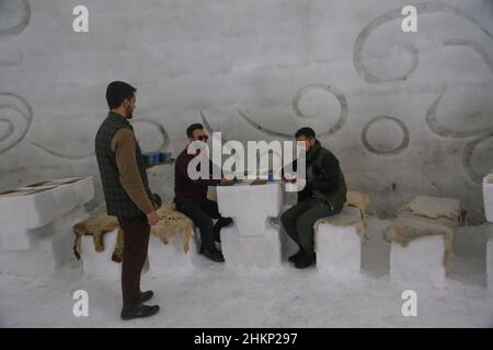 Kaschmir, Indien. 05th. Februar 2022. 5. Februar 2022, Srinagar, Jammu und Kashmir, Indien: Besucher sitzen und trinken im größten Iglu-Café Asiens aus Schnee in Gulmarg. Das Igloo Cafe ist etwa 37,5 Meter hoch und 45 Meter rund und bietet Platz für 15 Tische und etwa 60 Gäste. Das Igloo Cafe bietet Tische aus Eis und Schnee, an denen den Besuchern warme Gerichte serviert werden (Bild: © Sajad Hameed/Pacific Press via ZUMA Press Wire) Quelle: ZUMA Press, Inc./Alamy Live News Stockfoto