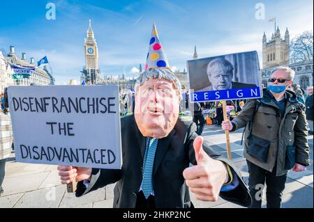 London, Großbritannien. 5th. Februar 2022. Eine Charikatur von Boris Johnson, Premierminister, fordert den Gesetzentwurf zur „Entrechtung der Benachteiligten“, der von einem Protestierenden hinter sich gestellt wird, sagt, er sei schuldig wie die Hölle und solle zurücktreten – macht Stimmen wichtig – Ein „Stop the Elections Bill“-Protest auf dem Parliament Square. Wenn das Gesetz angenommen würde, wäre es ein "Desaster für die Demokratie". Sie glauben nicht, dass der Wahlbetrug hoch genug ist, um die Verwendung einer Identifizierung bei der Abstimmung zu verdienen, was ihrer Meinung nach viele bereits marginalisierte Gruppen abschreckenlassen würde. Kredit: Guy Bell/Alamy Live Nachrichten Stockfoto