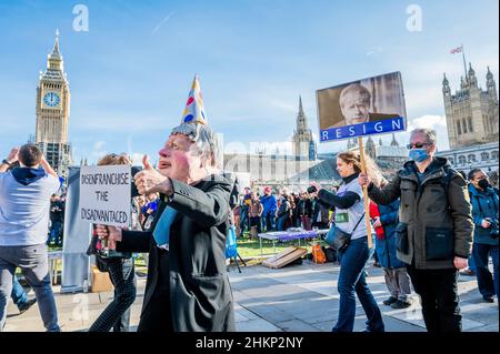 London, Großbritannien. 5th. Februar 2022. Eine Charikatur von Boris Johnson, Premierminister, fordert den Gesetzentwurf zur „Entrechtung der Benachteiligten“, der von einem Protestierenden hinter sich gestellt wird, sagt, er sei schuldig wie die Hölle und solle zurücktreten – macht Stimmen wichtig – Ein „Stop the Elections Bill“-Protest auf dem Parliament Square. Wenn das Gesetz angenommen würde, wäre es ein "Desaster für die Demokratie". Sie glauben nicht, dass der Wahlbetrug hoch genug ist, um die Verwendung einer Identifizierung bei der Abstimmung zu verdienen, was ihrer Meinung nach viele bereits marginalisierte Gruppen abschreckenlassen würde. Kredit: Guy Bell/Alamy Live Nachrichten Stockfoto