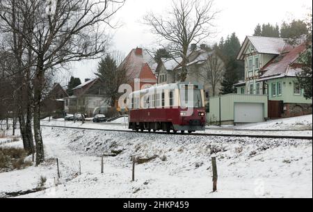 Sorge, Deutschland. 05th. Februar 2022. Ein Triebwagen der Harzer Schmalspurbahnen GmbH HSB fährt durch die Harzer Stadt Sorge. Das Wetter bietet derzeit Wintersportlern wenig Möglichkeiten im Harz für den Freizeitsport. Regen und Temperaturen über dem Gefrierpunkt haben die Schneemenge stark reduziert. Auch in den kommenden Tagen bleibt das Wetter wechselhaft bis warm. Quelle: Matthias Bein/dpa-Zentralbild/dpa/Alamy Live News Stockfoto