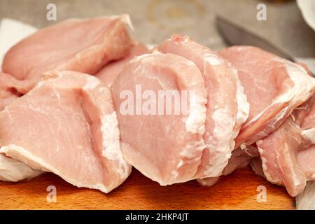 Viele ungekochte, frische, saftige, rohe Schweinekotelstückchen, frisch geschnitten, Essen, Objekt aus der Nähe, niemand. Unverarbeitetes Schweinefleisch, rohes Kotelett, Lende Cu Stockfoto