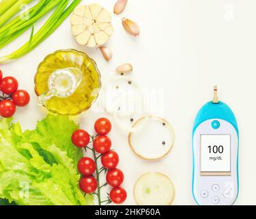 Diabeteskontrolle. Natürliches Gemüse, Olivenöl und Glucometer mit dem Ergebnis einer guten Glykämie auf weißem Hintergrund mit Kopierraum. Keto-Diät. Concep Stockfoto