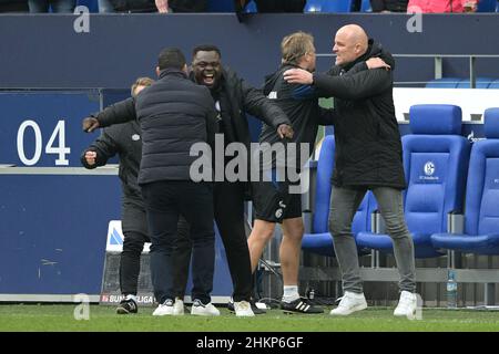 Gelsenkirchen, Deutschland. 05th. Februar 2022. Fußball: 2nd Bundesliga, FC Schalke 04 - Jahn Regensburg, Matchday 21, Veltins Arena: Schalkes Trainer Dimitrios Grammozis (l-r), Gerald Asamoah, Mike Büskens und Manager Rouven Schröder jubeln nach dem Schlusspfiff. Kredit: David Inderlied/dpa - WICHTIGER HINWEIS: Gemäß den Anforderungen der DFL Deutsche Fußball Liga und des DFB Deutscher Fußball-Bund ist es untersagt, im Stadion und/oder vom Spiel aufgenommene Fotos in Form von Sequenzbildern und/oder videoähnlichen Fotoserien zu verwenden oder zu verwenden./dpa/Alamy Live News Stockfoto