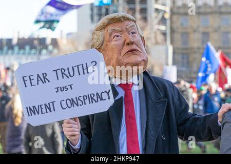 Mann in einem Kostüm und einer Maske von Donald Trump, der ein Schild mit der Aufschrift „Fear Truth“ auf einem Protest vor dem Parlament hält. London – 5th. Februar 2022 Stockfoto