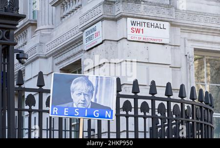 Ein Protestschild vor den Toren der Downing Street mit einem Bild von Boris Johnson mit dem Wort resignieren unten. Konzentrieren Sie sich auf das Zeichen. London – 5th. Februar 2022 Stockfoto