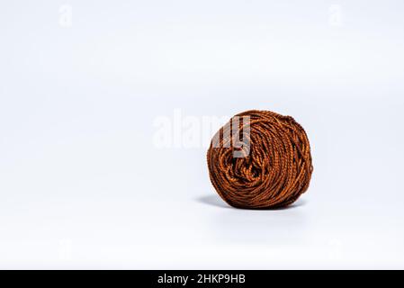 Mittelgroße e braune Garnkugel auf weißem Hintergrund Stockfoto