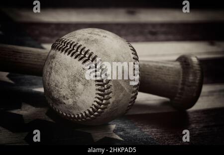 Nahaufnahme eines alten Baseballschlägers und eines traditionellen Holzschlägers auf einer rustikalen US-amerikanischen Holzflagge mit Vintage-Effekt Stockfoto