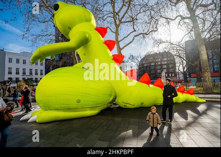 London, Großbritannien. 5th. Februar 2022. Die Menschen scheinen sich der risikoreichen Natur des „Dinosauriers“ nicht bewusst zu sein, während sie ihre Kinder damit spielen und posieren lassen - Ein riesiger, sexuell sugestive, aufblasbarer phallischer Dinosaurier in Leicester Square wirbt für den neuesten Jackass-Film - Jackass Forever. Kredit: Guy Bell/Alamy Live Nachrichten Stockfoto