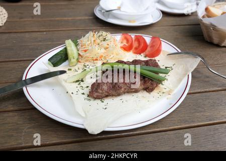 Das ist Kebab auf dem flachen Brot mit Gemüse Stockfoto