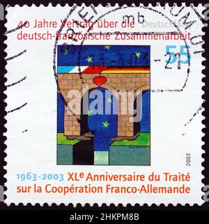 DEUTSCHLAND - UM 2003: Eine in Deutschland gedruckte Briefmarke zeigt Brücke mit Nationalflagge und Herz, 40th. Jahrestag des deutsch-französischen Kooperationsvertrages, Cir Stockfoto