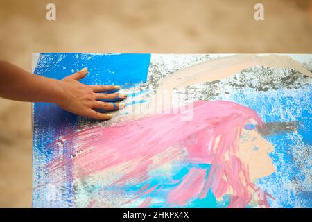 Frau Hand schmierende blaue Farbe auf Leinwand, Art Expression auf Outdoor Art Festival. Tropf Malerei Ausdruck, verschmierende und spritzt Farbe auf weiß ca. Stockfoto