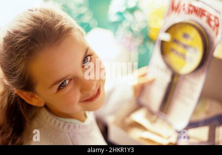 Mädchen (8-10) hält präsent und blickt lächelnd über die Schulter, Marysville, Washington Stockfoto