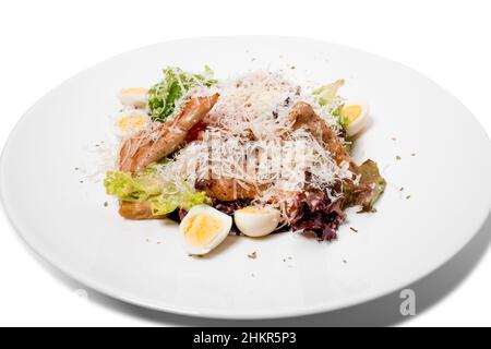 Warmer Salat mit gegrilltem Lachs und Wachteleiern. Isoliert auf weißem Hintergrund. Stockfoto