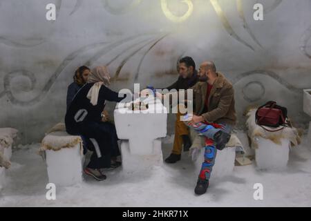 Srinagar, Indien. 05th. Februar 2022. Indische Touristen genießen am 5. Februar 2022 Tee im größten Iglu Cafe Asiens, das aus Schnee in Gulmarg, Srinagar, Indien, hergestellt wurde. Das Igloo Cafe ist etwa 37,5 Meter hoch und 45 Meter rund und bietet Platz für 15 Tische und etwa 60 Gäste. Das Igloo Cafe bietet Tische aus Eis und Schnee, wobei den Besuchern warme Gerichte serviert werden. (Foto: Sajad Hameed/Pacific Press/Sipa USA) Quelle: SIPA USA/Alamy Live News Stockfoto