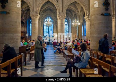 Paris, Frankreich - Menschenmassen besuchen Gläubige in der monumentalen religiösen Architektur der katholischen Kirche Notre Dame Kathedrale Stockfoto