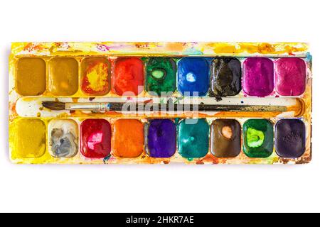Palette alte gebeizte Aquarellfarben und Pinsel, isoliert Stockfoto