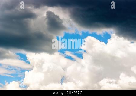 Dark Storm und White Cumulus Wolken am blauen Himmel, Hintergrund, Texturkonzept - der Kampf zwischen gut und Böse Stockfoto