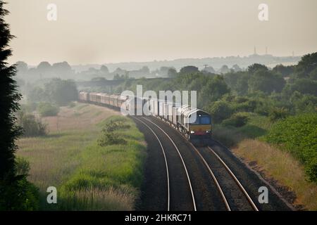 Direct Rail Services Lokomotiven der Baureihe 66, die einen Containerzug an einer Lokomotive der Baureihe 47 der Westküste vorbeischleppen. Stockfoto