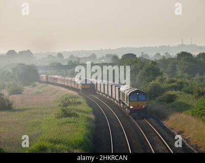 Direct Rail Services Lokomotiven der Baureihe 66, die einen Containerzug an einer Lokomotive der Baureihe 47 der Westküste vorbeischleppen. Stockfoto