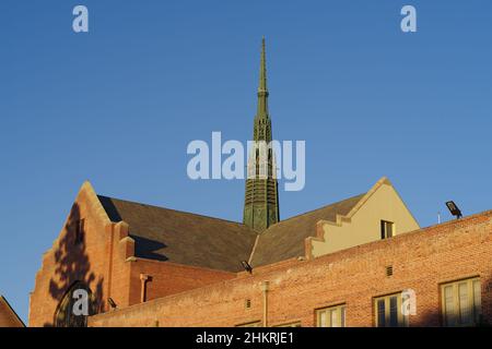 Dach und Kirchturm der First United Methodist Church vor einem blauen Nachmittagshimmel. Stockfoto