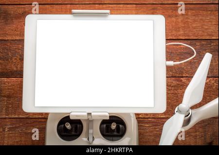 Modell eines digitalen Tablets mit einem leeren, isolierten Bildschirm (einschließlich Clipping Path), der auf einem Drohnenfunkcontroller montiert ist Stockfoto