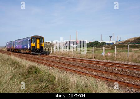 2 Sprinterzüge der nördlichen Eisenbahnlinie der Baureihe 153 der Baureihe 153301 + 153351 fahren an der nuklearen Wiederaufbereitungsanlage Sellafield auf der Bahnlinie der Küste von Cumbria vorbei Stockfoto