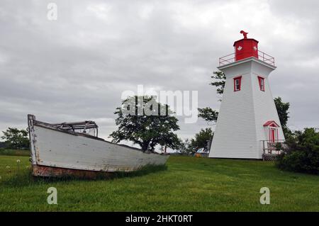 Ein altes Boot befindet sich in der Nähe des historischen Leards Range Front Lighthouse, in dem sich das Victoria Seaport Museum befindet, im südöstlichen Dorf Victoria, PEI. Stockfoto