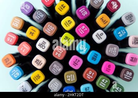 Eine Reihe von farbigen Markern, mehrfarbigen Markern, eine Draufsicht auf einem türkisfarbenen Hintergrund, das Konzept der Färbung und künstlerische Kreativität. Stockfoto