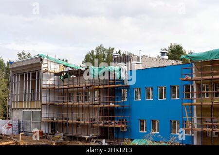 Der Fortschritt beim Bau des Kindergartengebäudes. Farbenfrohe, fröhliche, moderne Dekoration der Gebäudefassaden. Stockfoto