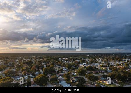 Luftaufnahme einer bedrohlichen, sich nähernden Sturmfront nach Westen mit Blick auf Baumkronen und die Vorstadtgemeinde Port Orange, Florida, USA. Stockfoto