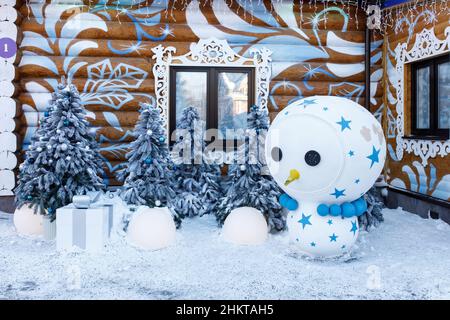 Moskau, Russland - 05. Februar 2022, das Moskauer Anwesen von Ded Moroz (russischer Weihnachtsmann) Schneemann und künstliche blaue Weihnachtsbäume in der Nähe des Hauses. Stockfoto