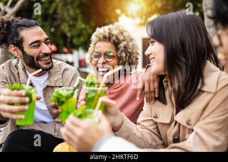 Multirassische Touristenfreunde lachen zusammen und haben Spaß beim Mojito trinken Stockfoto